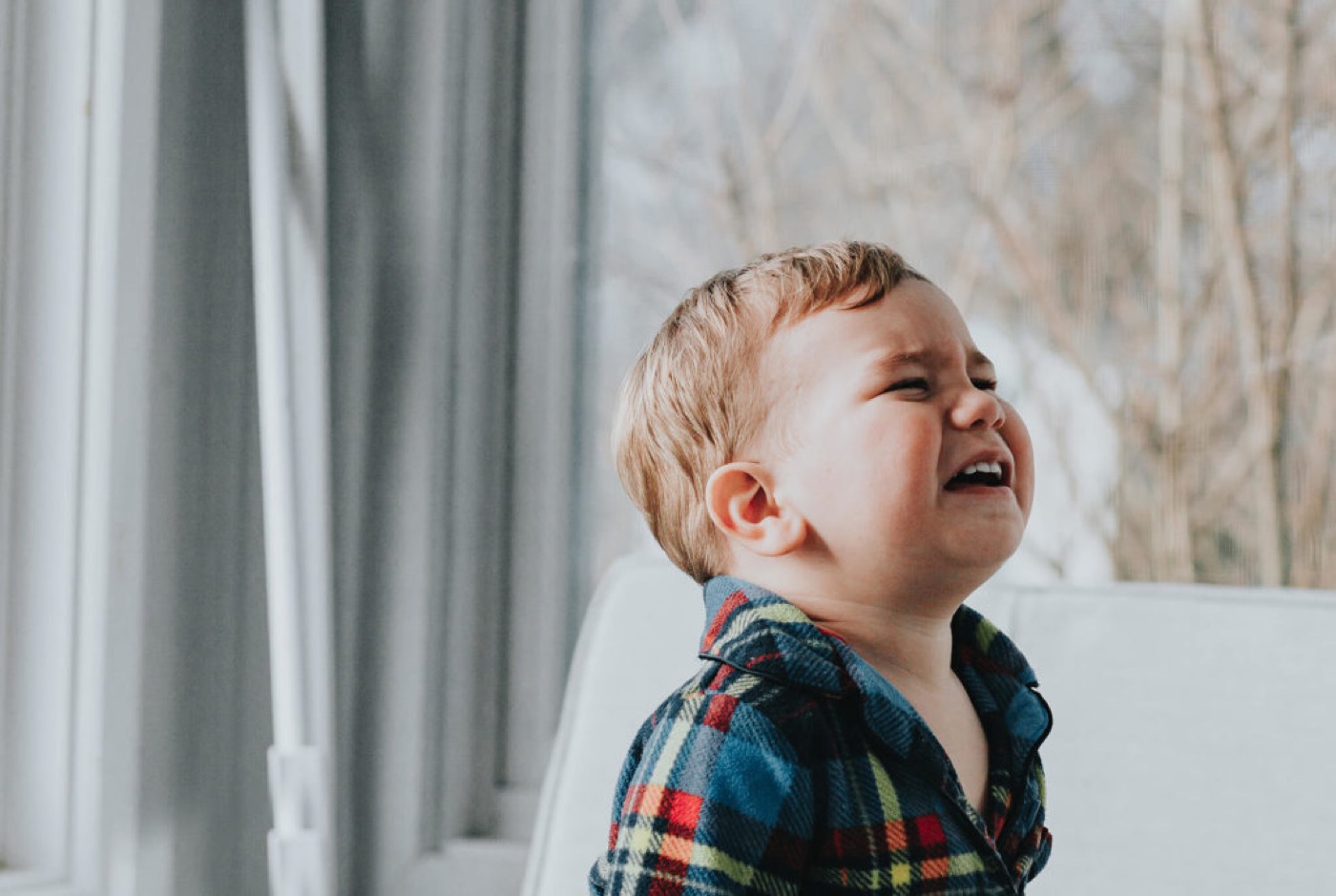 Little boy is experiencing discomfort and irritability because of gingivostomatitis