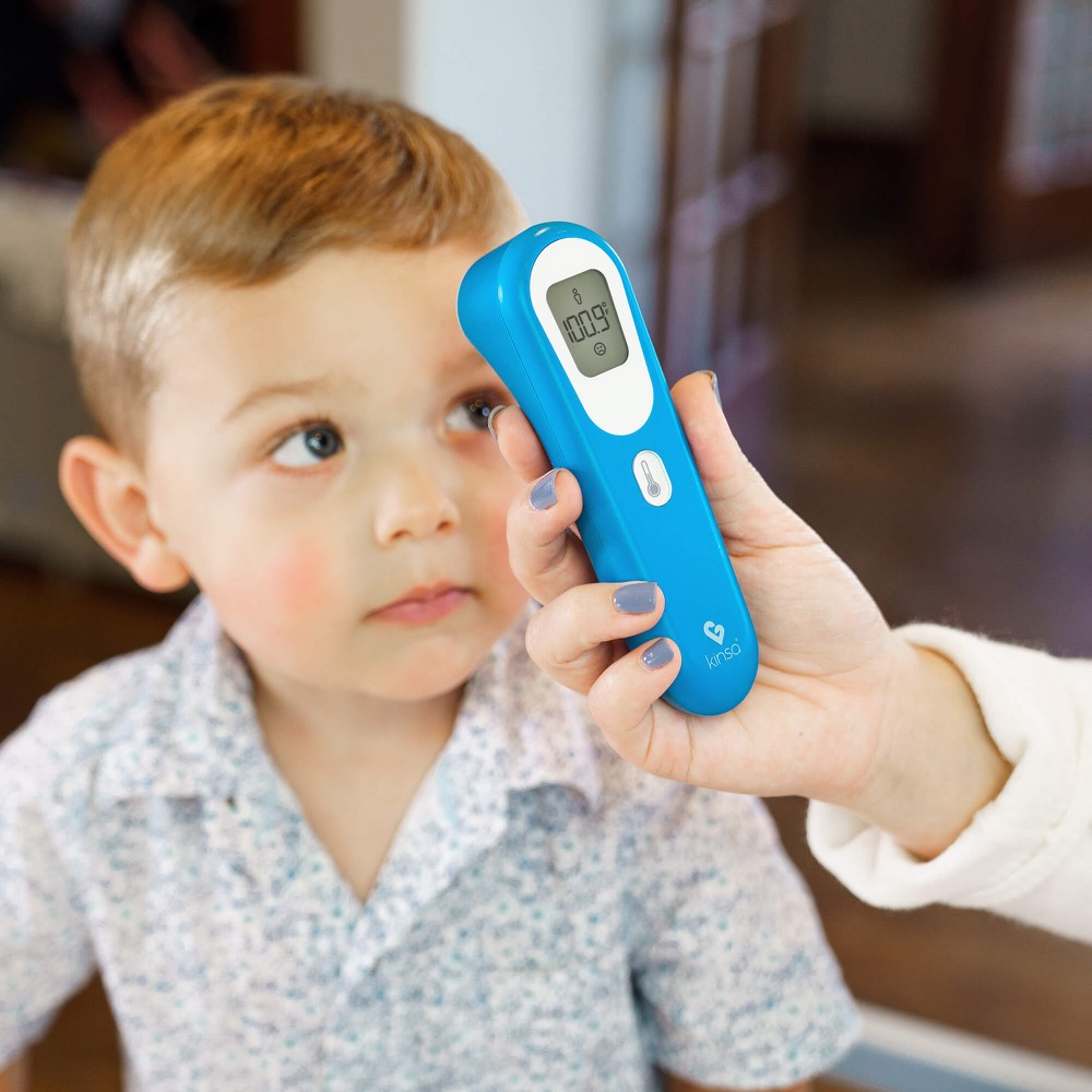 A parent taking a child’s temperature with the QuickScan forehead thermometer
